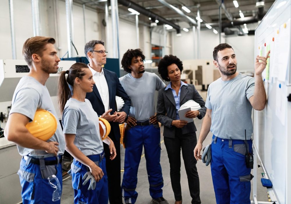 happy-manual-worker-presenting-results-business-development-while-giving-presentation-company-leaders-his-team-factory_637285-4144