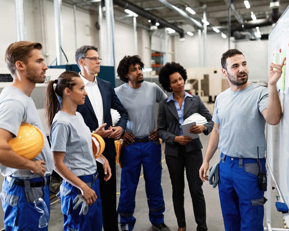happy-manual-worker-presenting-results-business-development-while-giving-presentation-company-leaders-his-team-factory_637285-4144